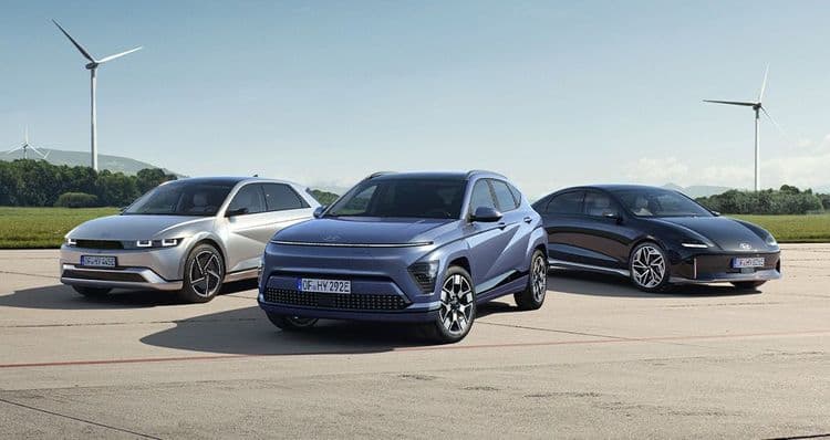 Hyundai IONIQ 5, Hyundai KONA Elektro and Hyundai IONIQ 6 stand on the field with wind turbines